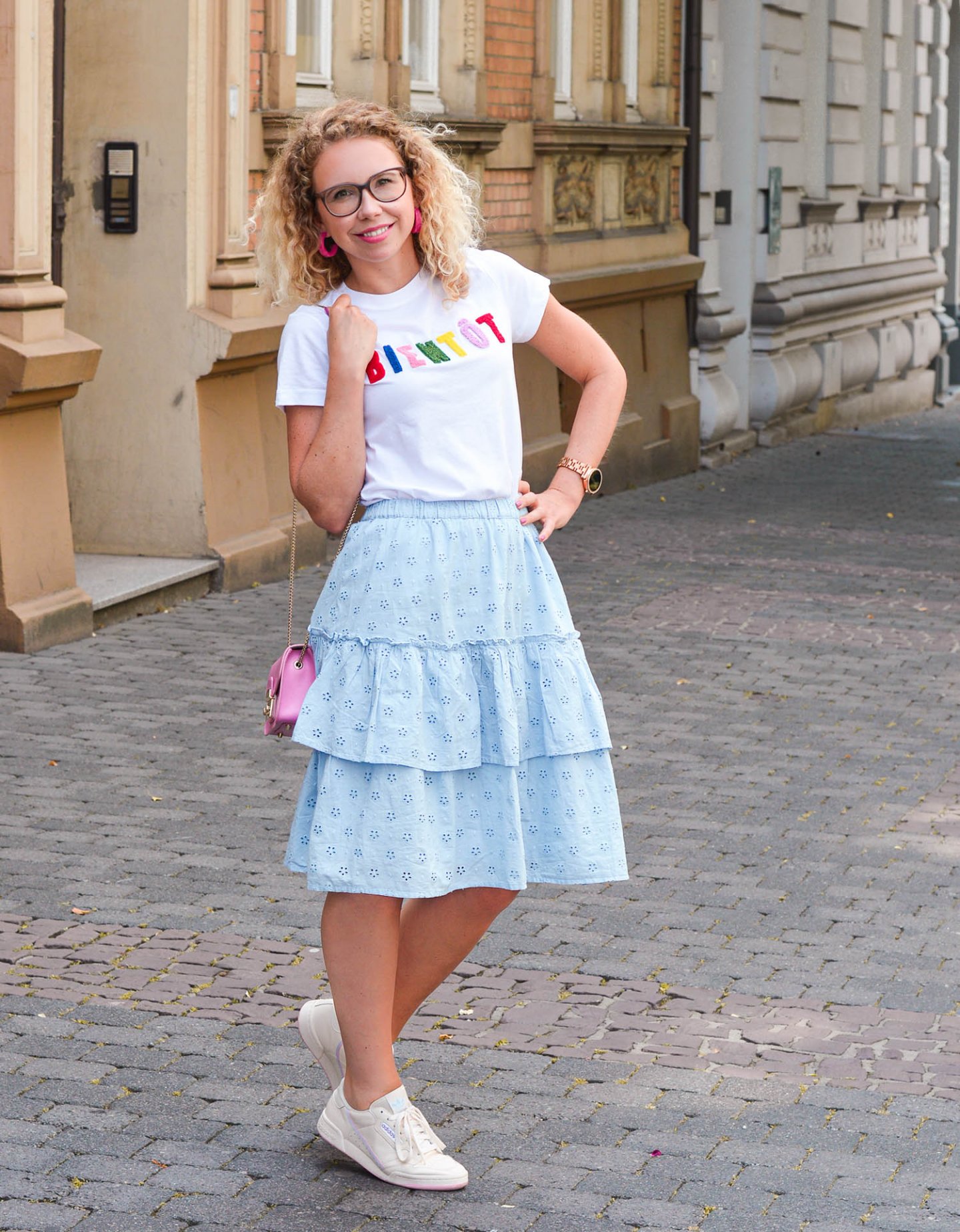 Stufenrock, Statement-Shirt und Sneaker