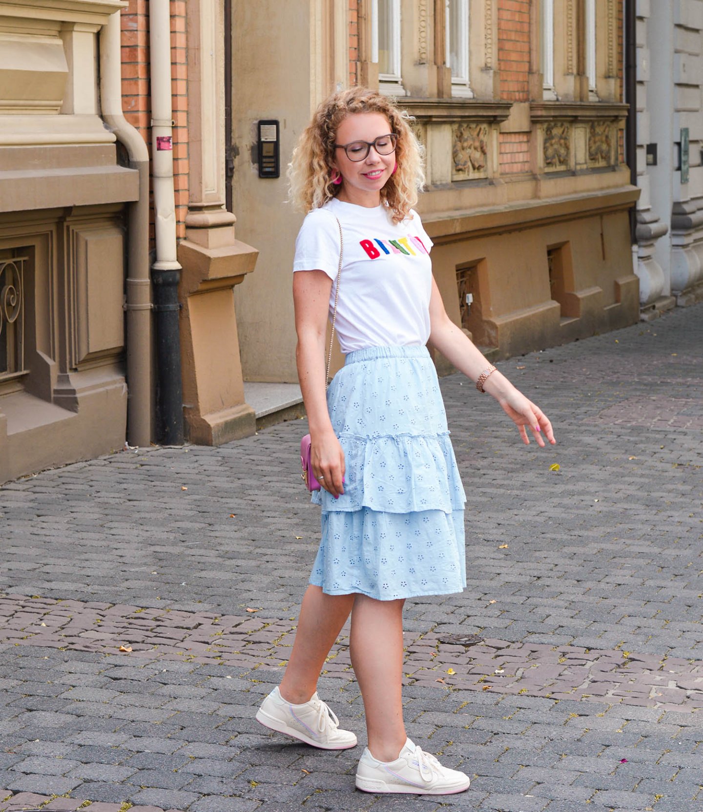 Stufenrock, Statement-Shirt und Sneaker